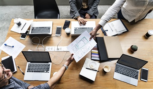 Team planning work around a desk with notes and coffee